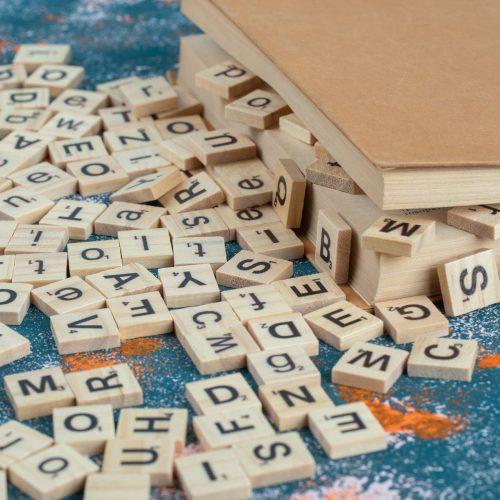 wooden dice with letters on them between the pages of a book
