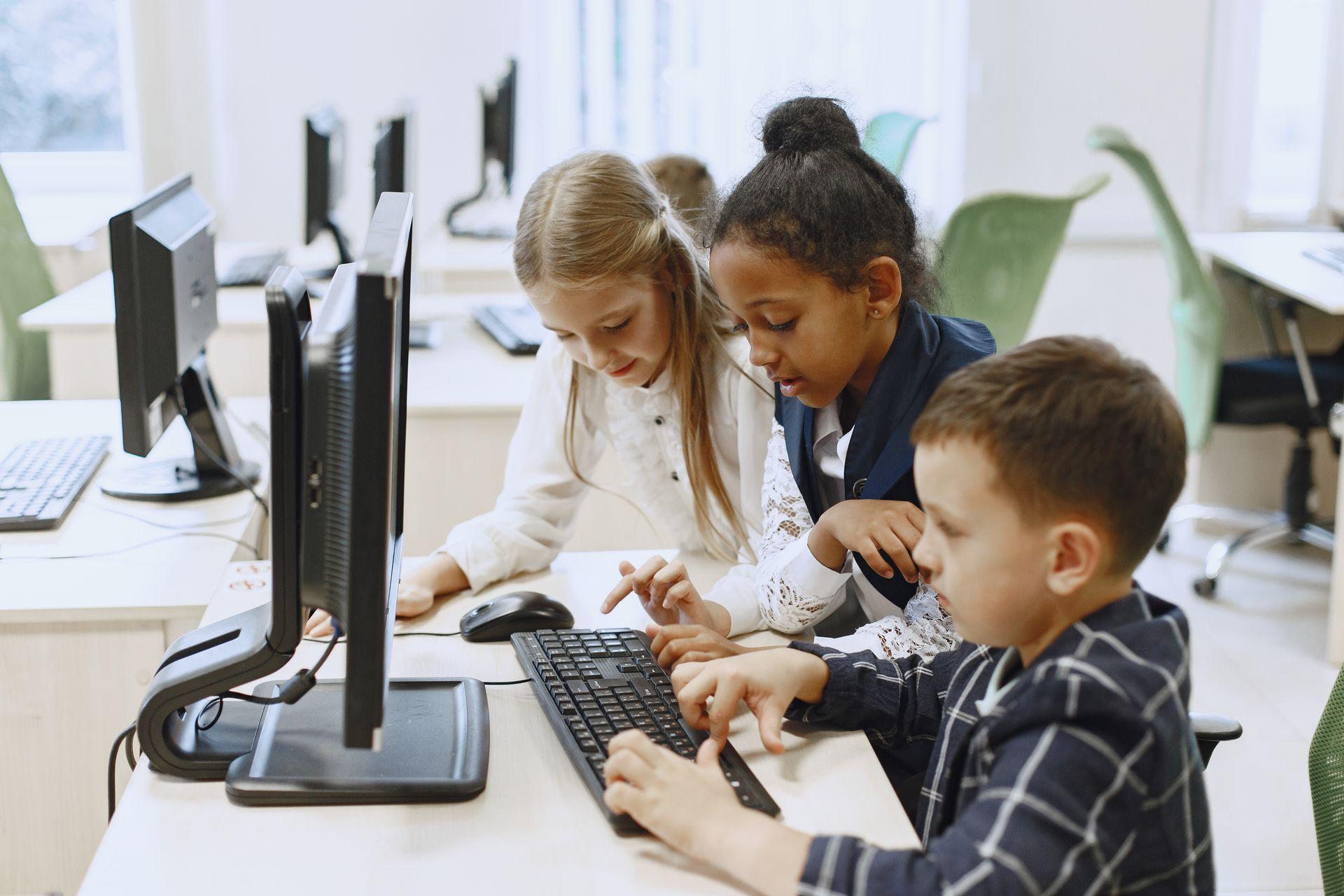 children sit at computers in the classroom.