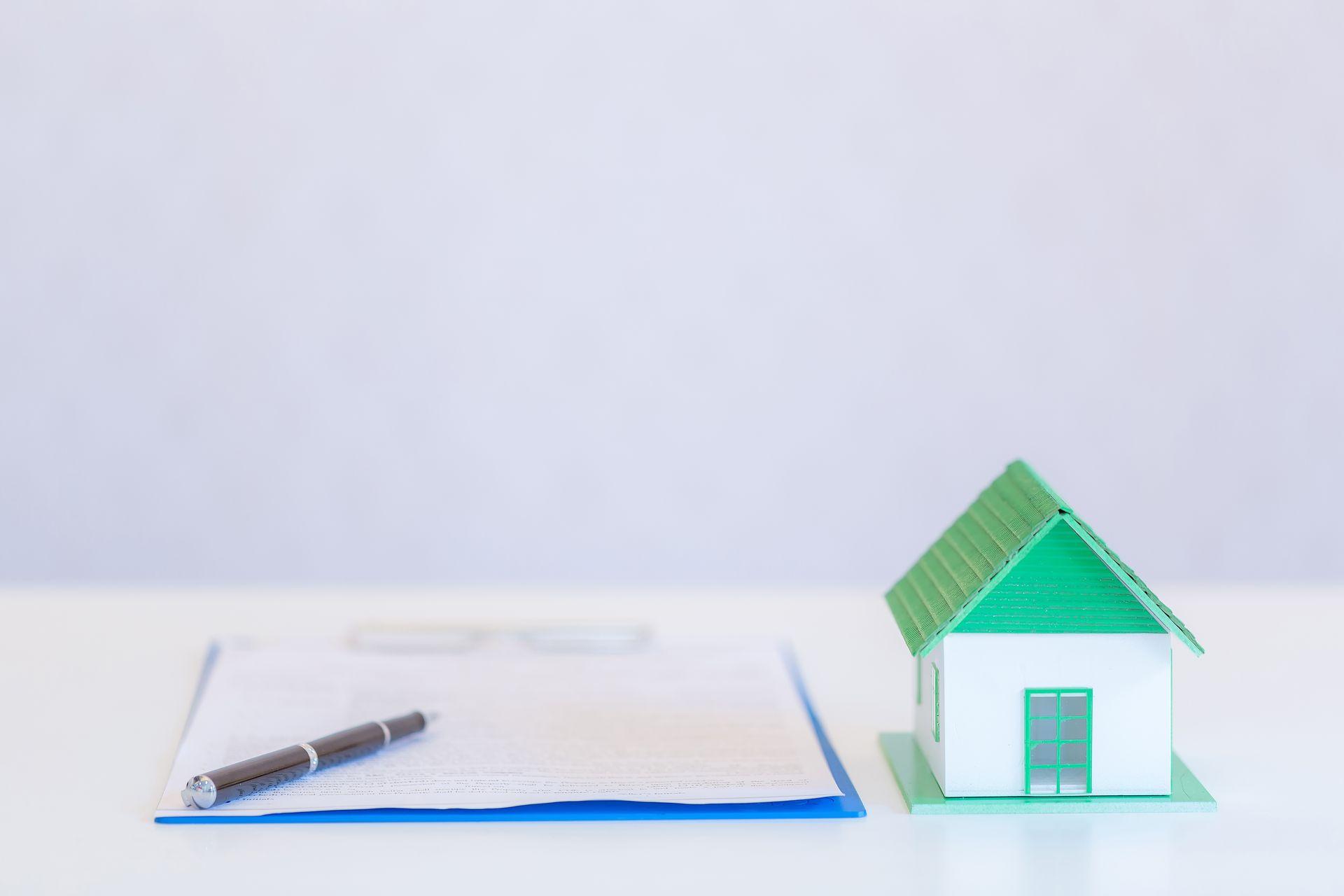 small houses modern design and documents with pen on white backg