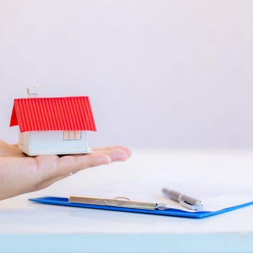 house in human hands on a white background