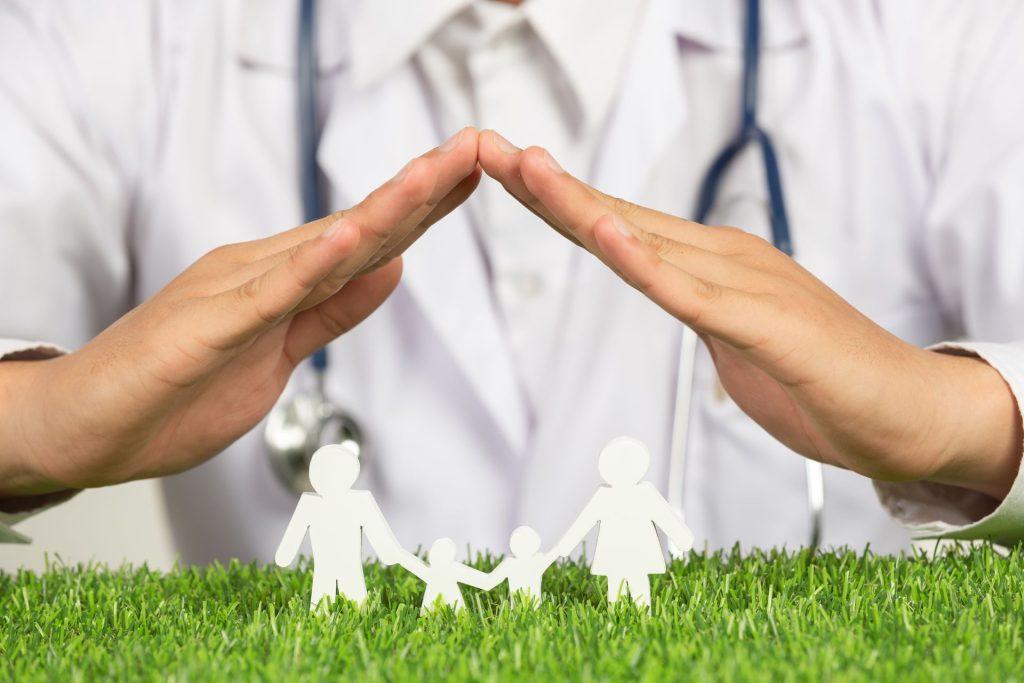 close up picture of doctor's hands posting symbol of home above