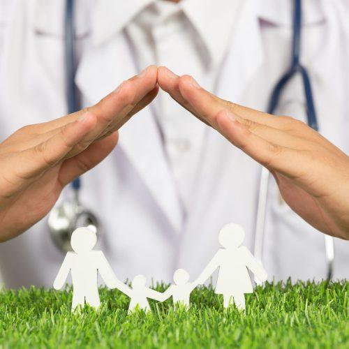 close up picture of doctor's hands posting symbol of home above